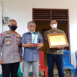 Bupati-Konawe-Kery-Saiful-Konggoasa-menunjukkan-trofi-penghargaan-dari-Menteri-Bahlil.