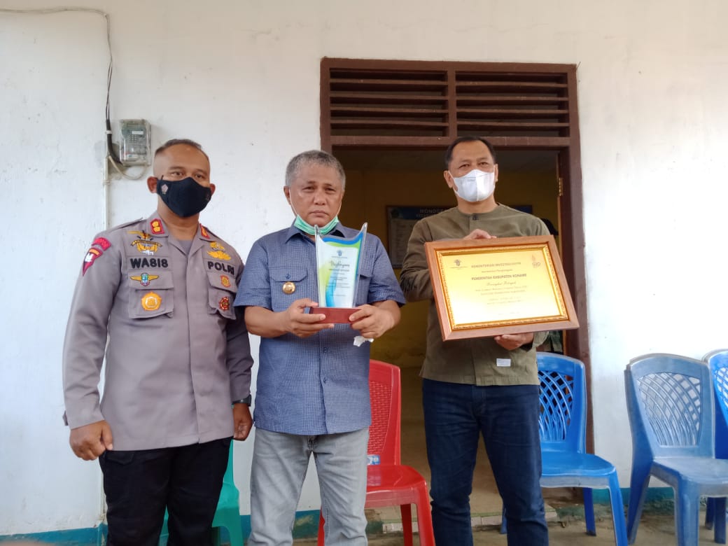 Bupati-Konawe-Kery-Saiful-Konggoasa-menunjukkan-trofi-penghargaan-dari-Menteri-Bahlil.