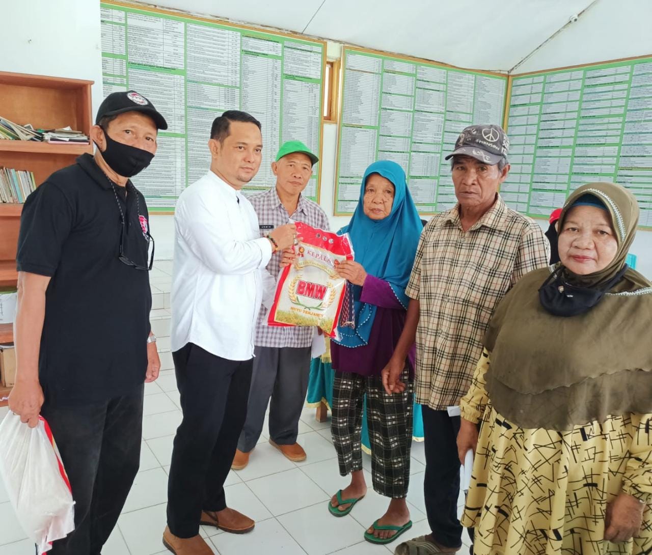 Perwakilan Pengurus KKSS Kota Kendari, Ridwan Zainal (kedua dari kiri) menyerahkan bantuan sembako kepada warga prasejahtera di Kelurahan Abeli, Jumat (11/02/2022). (FOTO : AGUS SETIAWAN / KENDARI NEWS)
