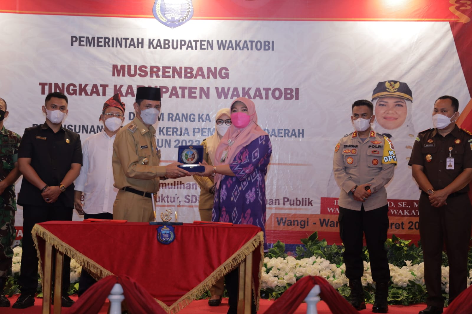 Bupati Wakatobi, Haliana (kiri) didampingi Forkopimda menyerahkan cinderamata kepada Kepala BPJS Ketenagakerjaan Sultra, Minarni Lukman (kanan) usai menyepakati kerjasam perlindungan sosial ketenagakerjaan, Senin (22/03/2022).