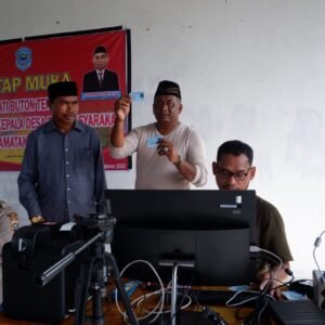 Bupati Buteng, H.Samahuddin menunjukkan e-KTP salah satu warganya yang baru selesai dibuat dengan alat perekaman Adminduk di Kecamatan Talaga Raya.