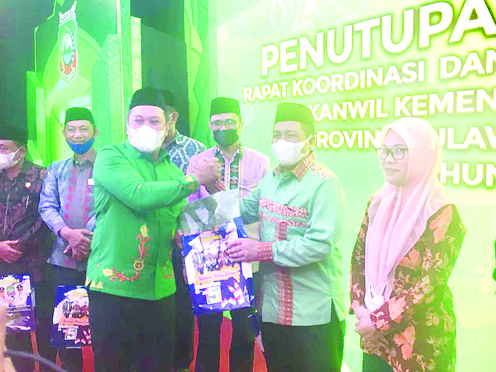 Bupati Konut Ruksamin menyerahkan cenderamata kepada Ketua DPW BKPRMI Sultra H. Zainal Mustamin