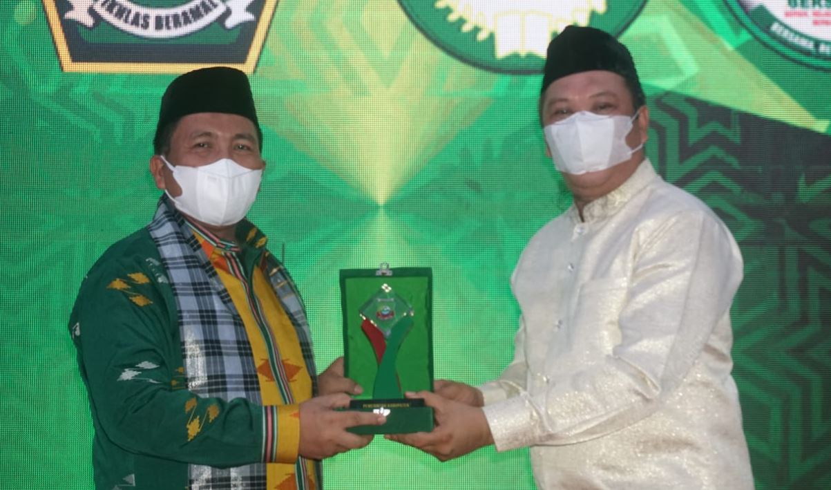 Bupati Konut Ruksamin (Kanan) saat menyerahkan cendramata kepada Kepala Kemenag Sultra Zainul Mustamin.