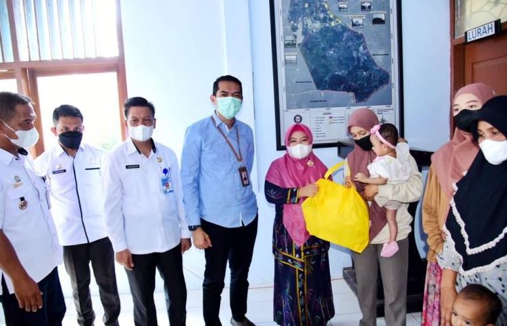 Ketua TP PKK Kota Kendari, Hj. Sri Lestari (kelima dari kiri) didampingi Kepala Disdalduk dan KB Kota Kendari Jahudding (ketiga dari kiri) dan perewakilan Bank Sultra saat menyalurkan bantuan program Dashat.