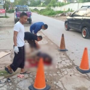 Dua warga saat mengevakuasi korban kecelakaan tunggal, La Ode Muhammad Amzal, kemarin.