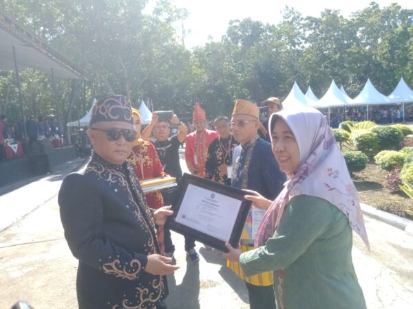 Bupati Konawe, Kery Saiful Konggoasa menyerahkan sertifikat akreditasi A kepada Runi selaku Kasek SMPN 1 Sampara