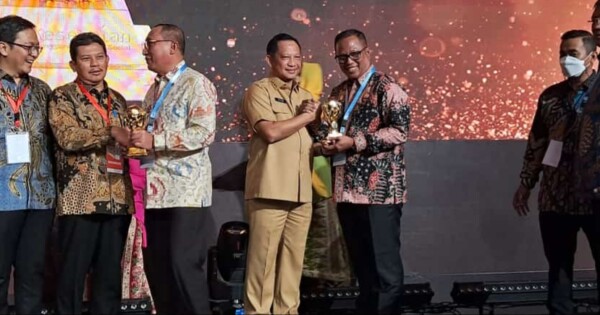 Menteri Dalam Negeri, Tito Karnavian menyerahkan penghargaan UHC kepada Pj Bupati Mubar, Bahri.