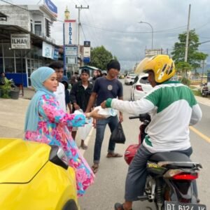 Pj. Ketua PKK Bombana, Hj Fatmawati Kasim Marewa saat membagikan secara langsung menu buka puasa ke masyarakat Bombana yang tengah berkendara di jalan Yos Sudarso