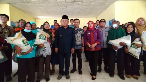 Bupati Konawe, Kery Saiful Konggoasa (berkopiah) berpose bersama dengan masyarakat penerima bantuan pangan di Pondidaha, kemarin