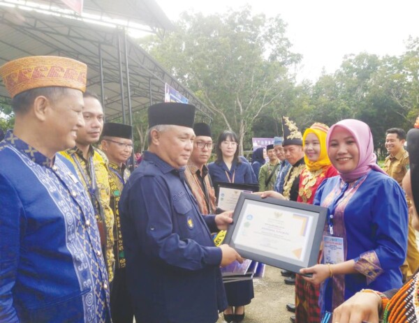 Bupati Konawe, Kery Saiful Konggoasa, menyerahkan penghargaan berdedikasi kepada ASN lingkup Dikbud Konawe, saat upacara Hardiknas 2023 di pelataran kantor Pemkab Konawe, Kamis (4/5).