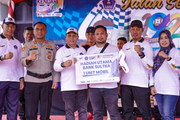 Penjabat Wali Kota Kendari, Asmawa Tosepu (kedua dari kanan) didampingi Ketua TP PKK, Chomza Asmawa (paling kanan), Dirut Bank Sultra, Abdul Latif (ketiga dari kiri) dan Kapolresta Kendari Kombes Pol M. Eka Faturrahman (kedua dari kiri) menyerahkan doorprize 1 unit mobil kepada warga yang beruntung memenangkan undian jalan sehat dalam rangka HUT Kota Kendari.