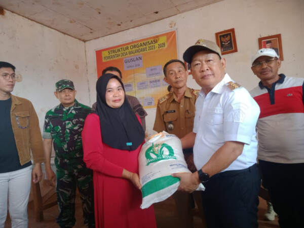 Pj Bupati Konawe Harmin Ramba, saat menyalurkan bantuan beras bagi warga desa Walandawe, Sabtu (21/10), bertempat di balai desa Walandawe kecamatan Routa.