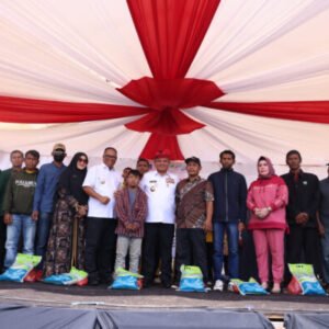 Pj Gubernur Sultra, Andap Budhi Revianto didampingi Pj Bupati Muna Barat, Bahri dan sejumlah pejabat foto bersama penerima bantuan sosial.