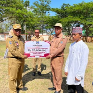 Pj Bupati Mubar, Dr. Bahri (kiri) menyerahkan secara simbolis beasiswa prestasi kepada orang tua atlet Taekwondo yang berhasil menjuarai salah kejuaraan internasional. FOTO: Akhirman