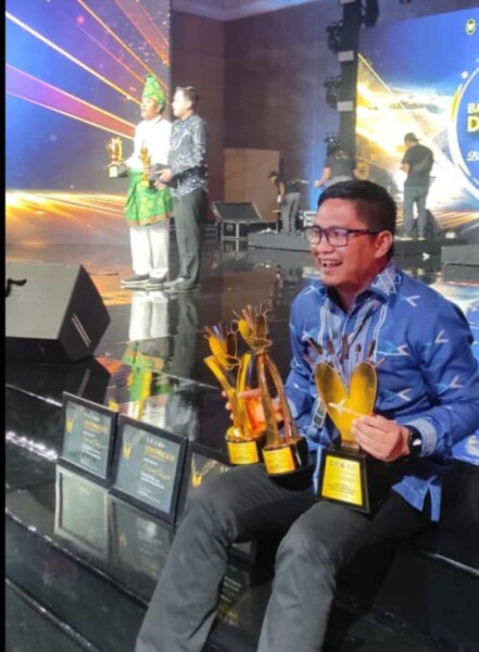 Kadis Pariwisata Sultra, Belli Tombili memperlihatkan tiga piala yang didapat dalam ajang BBWI 2023, Jumat malam (15/12/2023). FOTO: IST