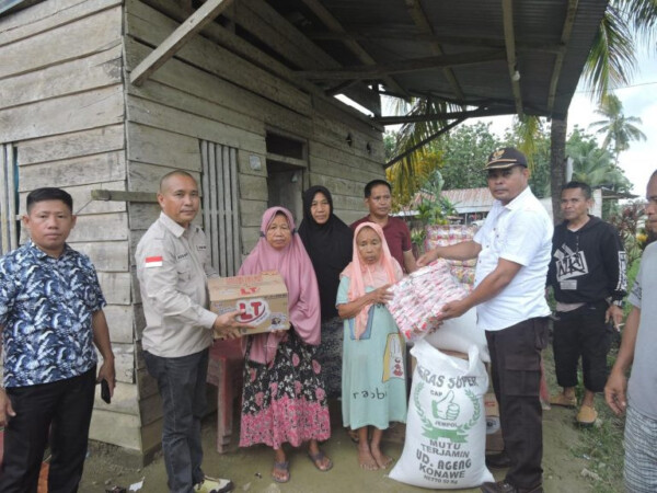 Wakil Ketua II DPRD Konawe Rusdianto (dua dari kiri), saat menyalurkan bantuan pangan bagi korban puting beliung di desa Uelawu