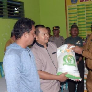 PENYALURAN BANSOS : Pj Wali Kota Kendari, Muhammad Yusup (paling) menyalurkan bantuan pangan kepada masyarakat kurang mampu. (AGUS SETIAWAN/KENDARI POS)