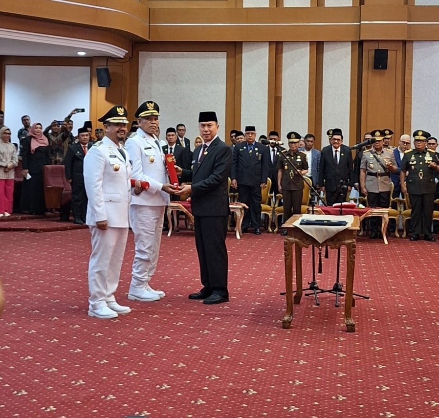 Gubernur Sultra Andi Sumangerukka (kanan) saat melantik Bupati Buton Tengah Azhari (kiri) dan Wakil Bupati Buton Tengah Muh. Adam Basan (2 dari kiri) di ruang pola Kantor Gubernur Sultra pada Jumat (21/3/2025)